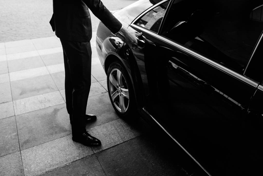 Valet's Hand Opening Grey Car Door On Street