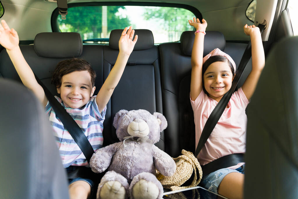 Yes! Cheerful little siblings sitting in the car while celebrating