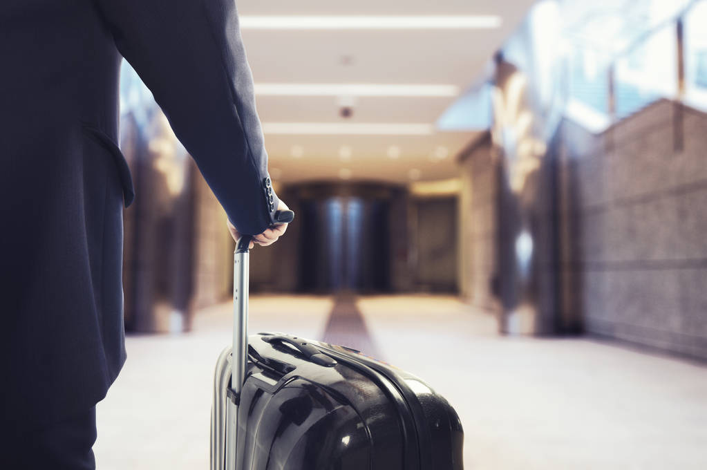 Businessman walking in the airport with suitcase