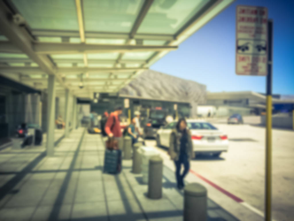Blurred people waiting for pickup at airport arrival terminal. 