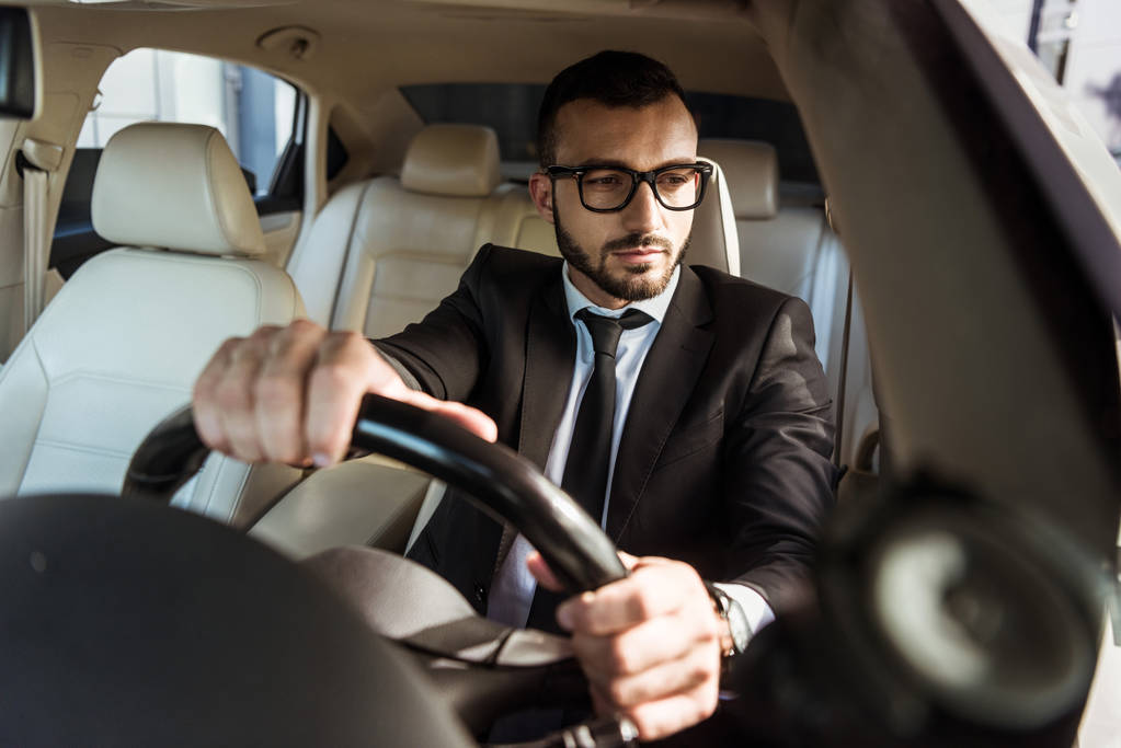 Driver in suit driving a car
