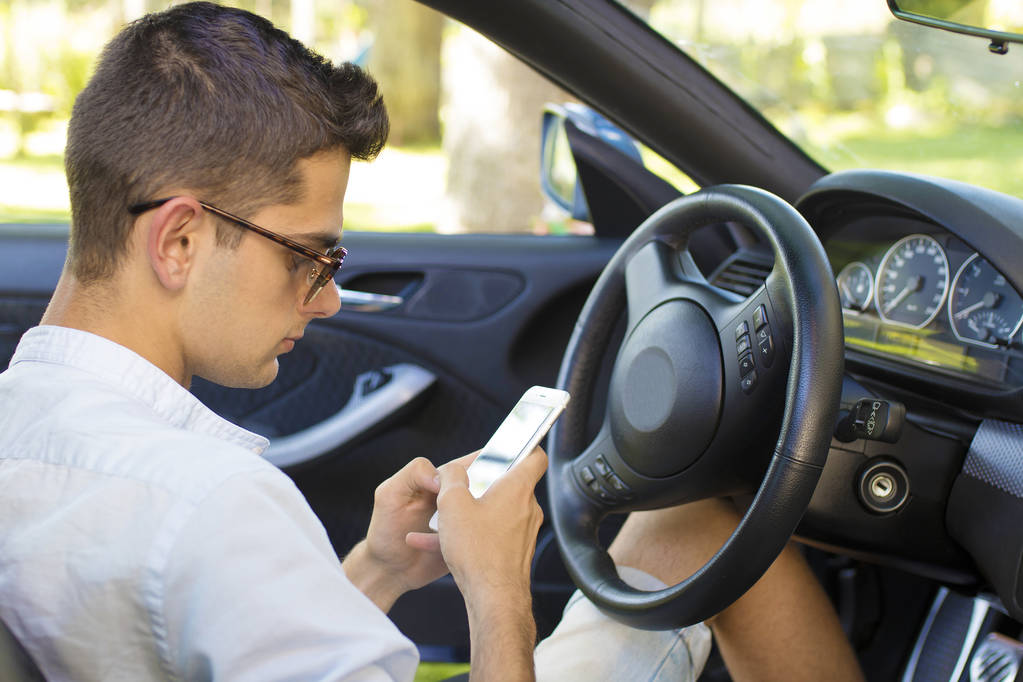 young man with the cellphone in the car