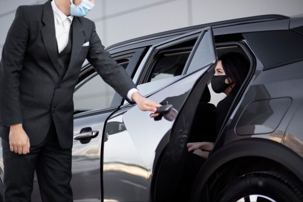 Young driver is opening door for a client