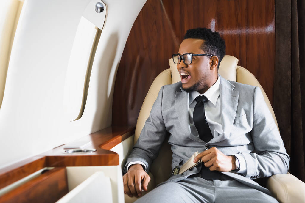 Person holding seatbelt ina plane