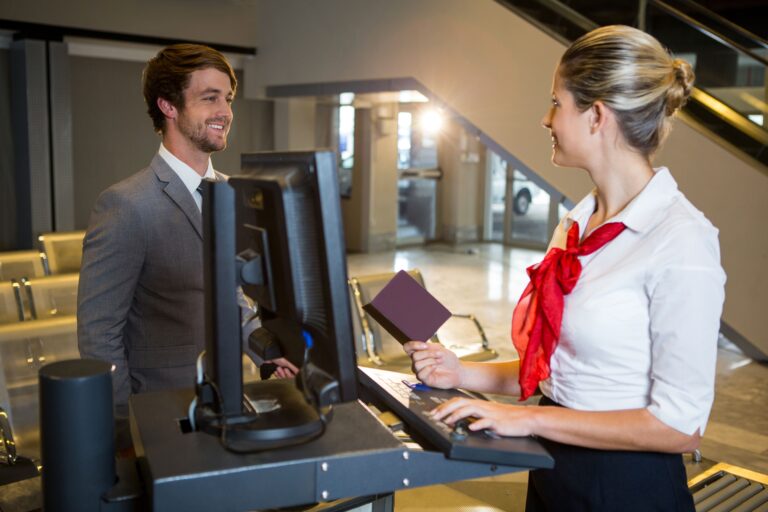 businessman-interacting-with-female-airport-staff-check-desk